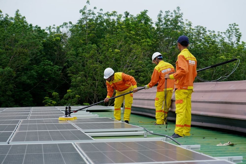Technicians cleaning a rooftop solar array